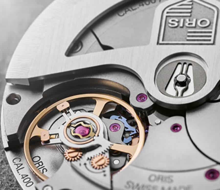 Montre Oris avec mouvement mécanique visible et détails en or rose.
